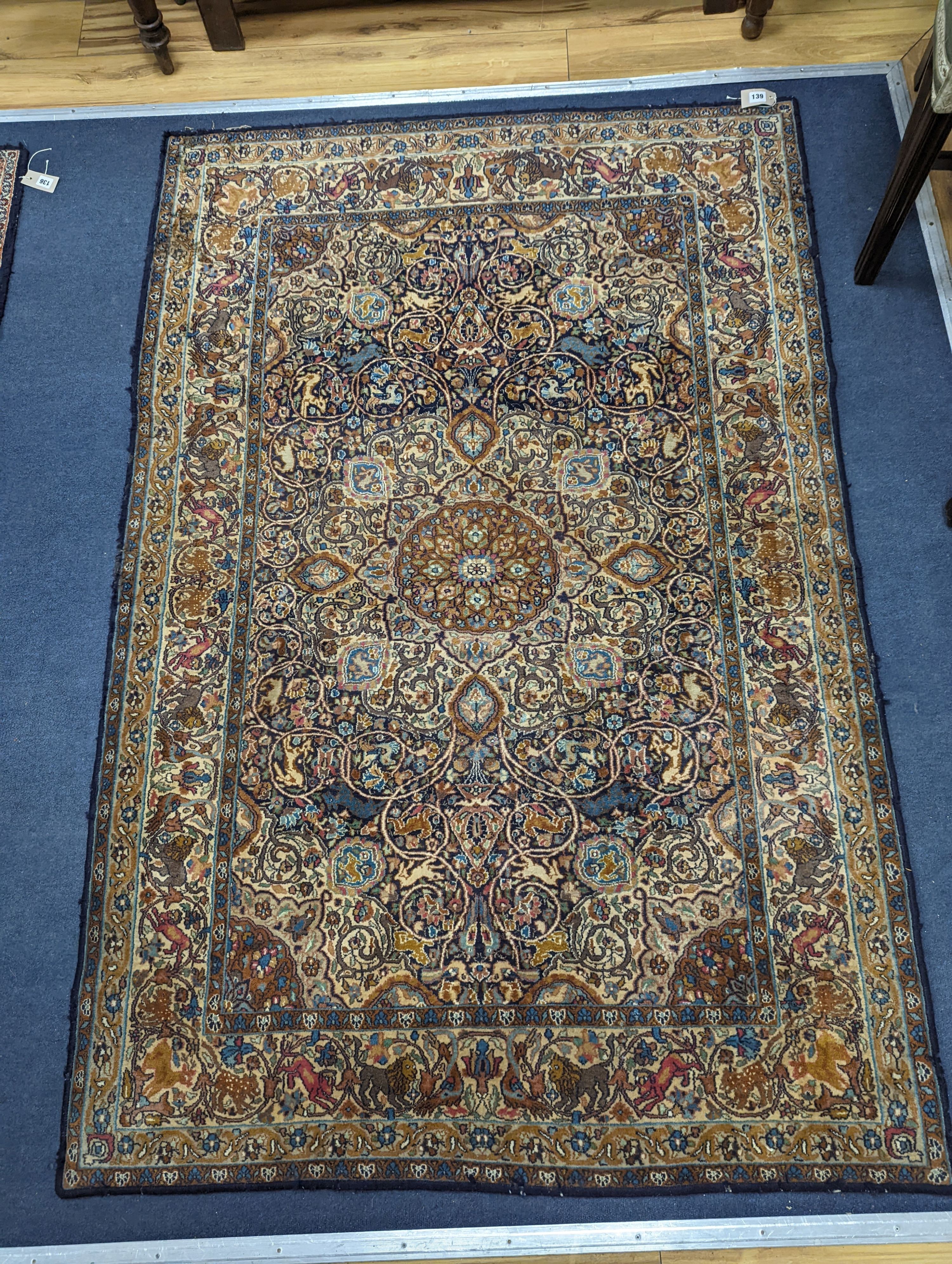 A Kashan blue ground rug woven with animals. 187x125cm.